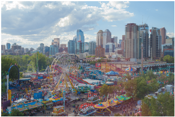 Calgary Stampede fairground with rides and city skyline Calgary Stampede fairground with rides and city skyline