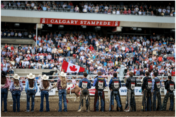 Rodeo participants at Calgary Stampede with Canada flag Rodeo participants at Calgary Stampede with Canada flag