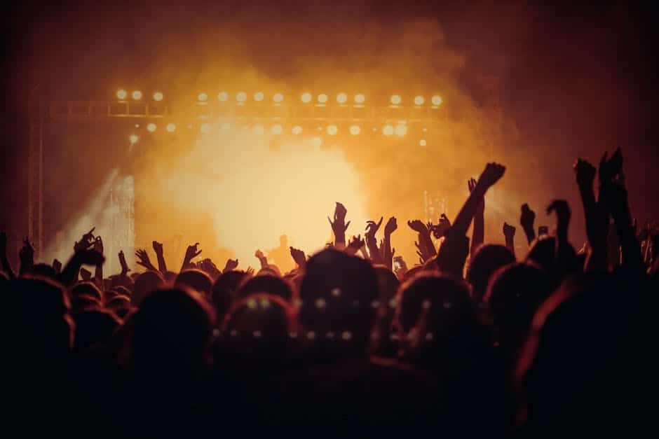 pexels-photo-1105666-1105666 Energetic music concert with a vibrant crowd cheering under bright stage lights.